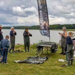 Flere personer i waders med udsigt til hav og skov