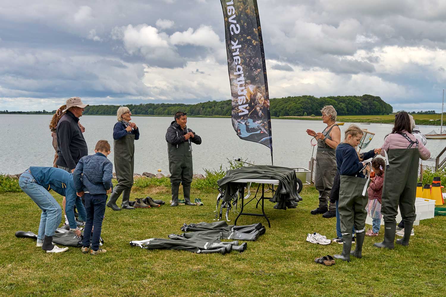 Flere personer i waders med udsigt til hav og skov
